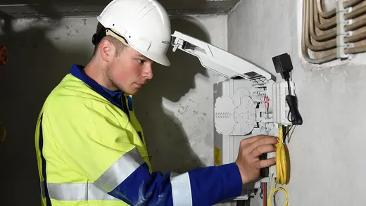 Mitarbeiter arbeitet am Glasfaserabschlusspunkt.