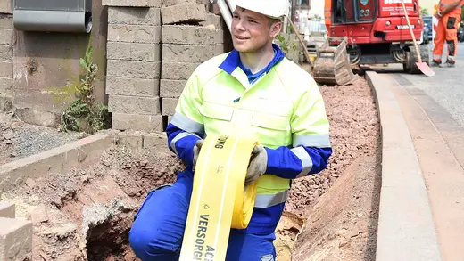 Mitarbeiter verlegt ein Trassenwarnband.