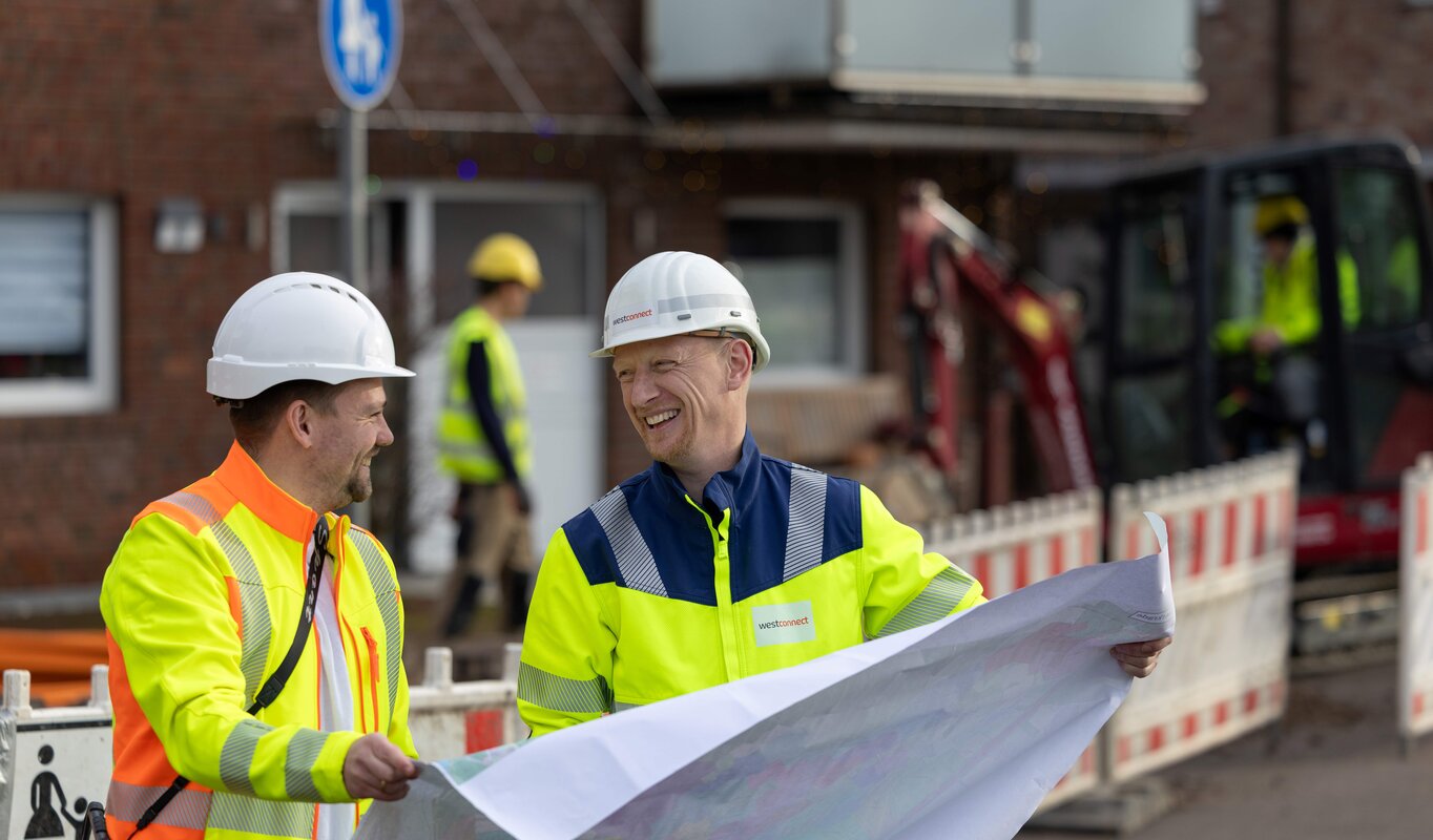 Zwei Mitarbeiter schauen sich einen Plan an.
