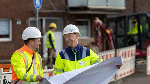 Zwei Mitarbeiter schauen sich einen Plan an.