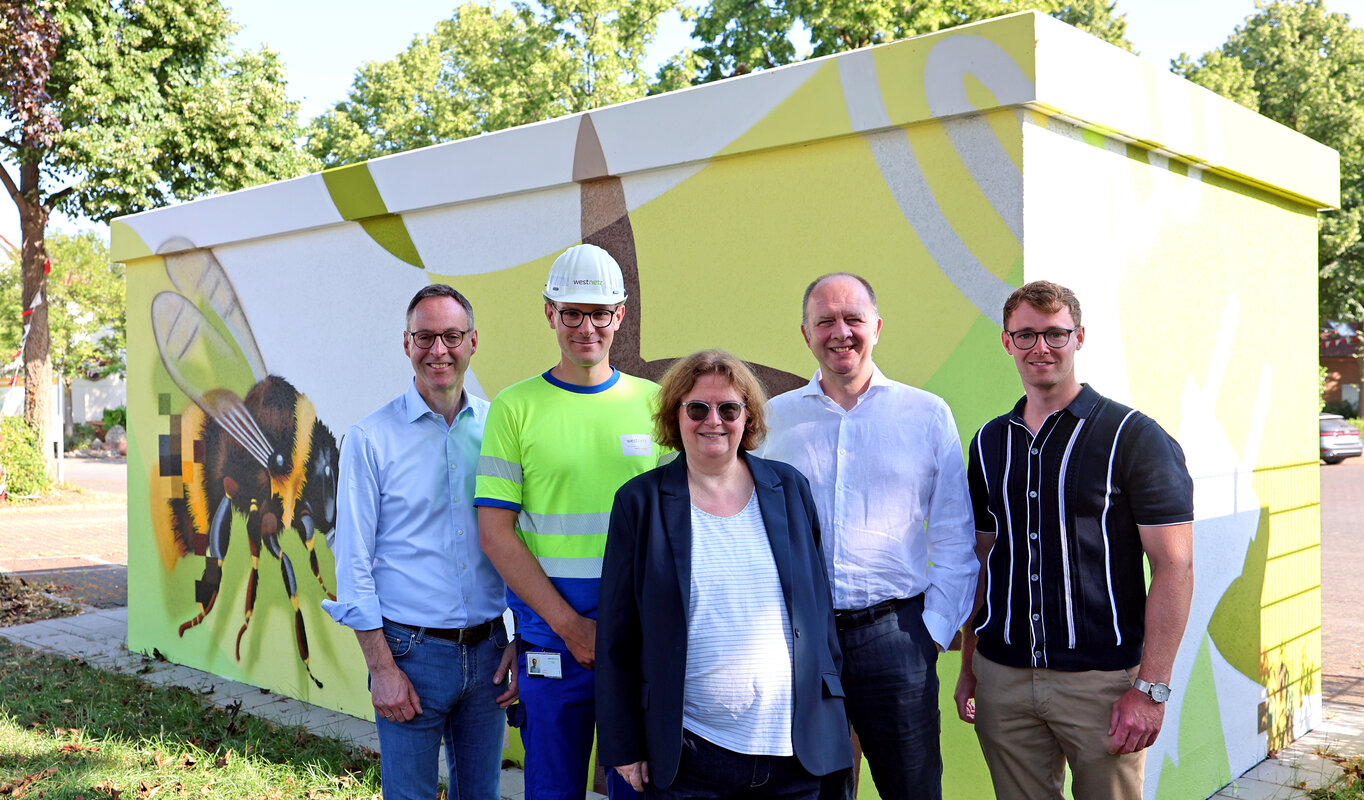 Auf dem Foto sind fünf Personen zu sehen, darunter Theo Mettenborg (Bürgermeister Rheda-Wiedenbrück), Lukas Dülberg (Projektleiter Westnetz), Birgit Büscher (Managerin für regionale Kooperationen, Westconnect), Dr. Peter Brautlecht (Regionalmanager, Westconnect) und Sebastian Czoske (Wirtschaftsförderer, Rheda-Wiedenbrück).