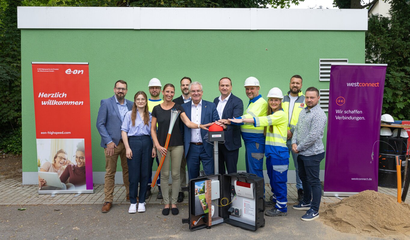 Auf dem Foto sind elf Personen zu sehen, darunter Marcel Thelen (Gigabitkoordinator, Stadt Mülheim), Nele Haupt (Koordination Digitale Infrastruktur, Stadt Mülheim), Peter Sosna (Rolloutmanager, Westconnect), Juliane Neubner (Amtsleiterin Digitalisierung und IT, Stadt Mülheim), Marcus Lehmann (Geschäftsführer, GRAF Rohrleitungs- und Tiefbau GmbH), Marc Buchholz (Oberbürgermeister, Stadt Mülheim), Carsten Lagemann (Geschäftsführer, Westconnect), Oliver Sauerbach (Leiter Region Ruhr, Westnetz), Sandra Etterichretz (Managerin für Regionale Kooperationen, Westconnect), Alexander Wagner (Bauleiter Tief- und Straßenbau, GRAF Rohrleitungs- und Tiefbau GmbH) und Adrian Binda (Bauleiter Tief- und Kabelbau, GRAF Rohrleitungs- und Tiefbau GmbH).