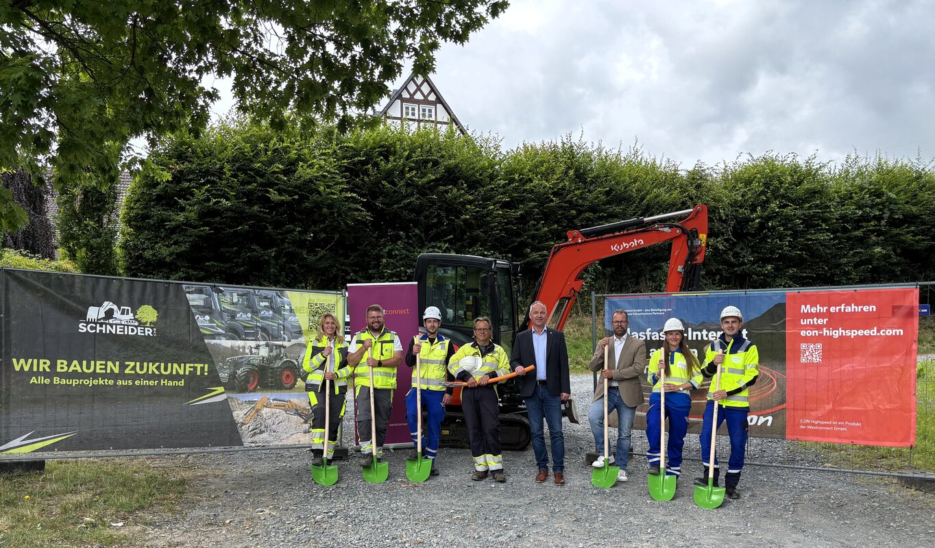 Auf dem Foto sind acht Personen zu sehen, darunter Jessica Strack (Projektleiterin der Schneiderbau GmbH), Louis Schneider (Bauleiter der Schneiderbau GmbH), Philip Wilk (Ausführungsplanung der Westnetz GmbH), Michael Eberley (Bauüberwachung der Westnetz GmbH), Christoph Rosenau (Bürgermeister der Gemeinde Bestwig), Alexander Böer (Breitbandkoordinator der Gemeinde Bestwig), Sandra Etterichretz (Managerin für Regionale Kooperationen der Westconnect GmbH) und Robert Ilievski (Projektleitung der Westnetz GmbH).