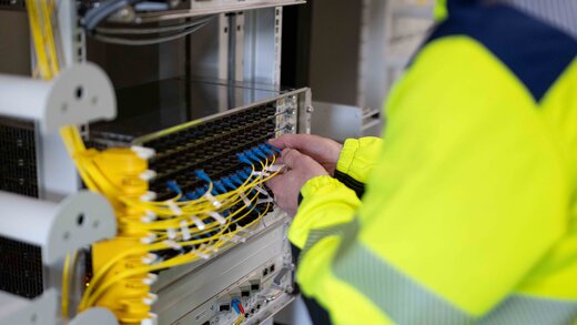 Ein Mitarbeiter patcht ein Glasfaserkabel.