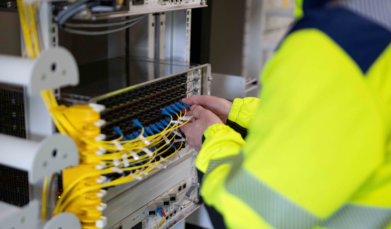 Ein Mitarbeiter patcht ein Glasfaserkabel.