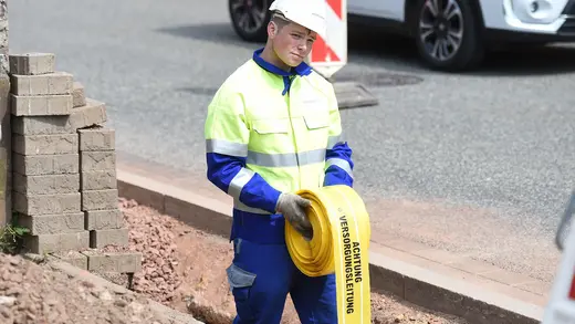 Mitarbeiter verlegt ein Trassenwarnband.