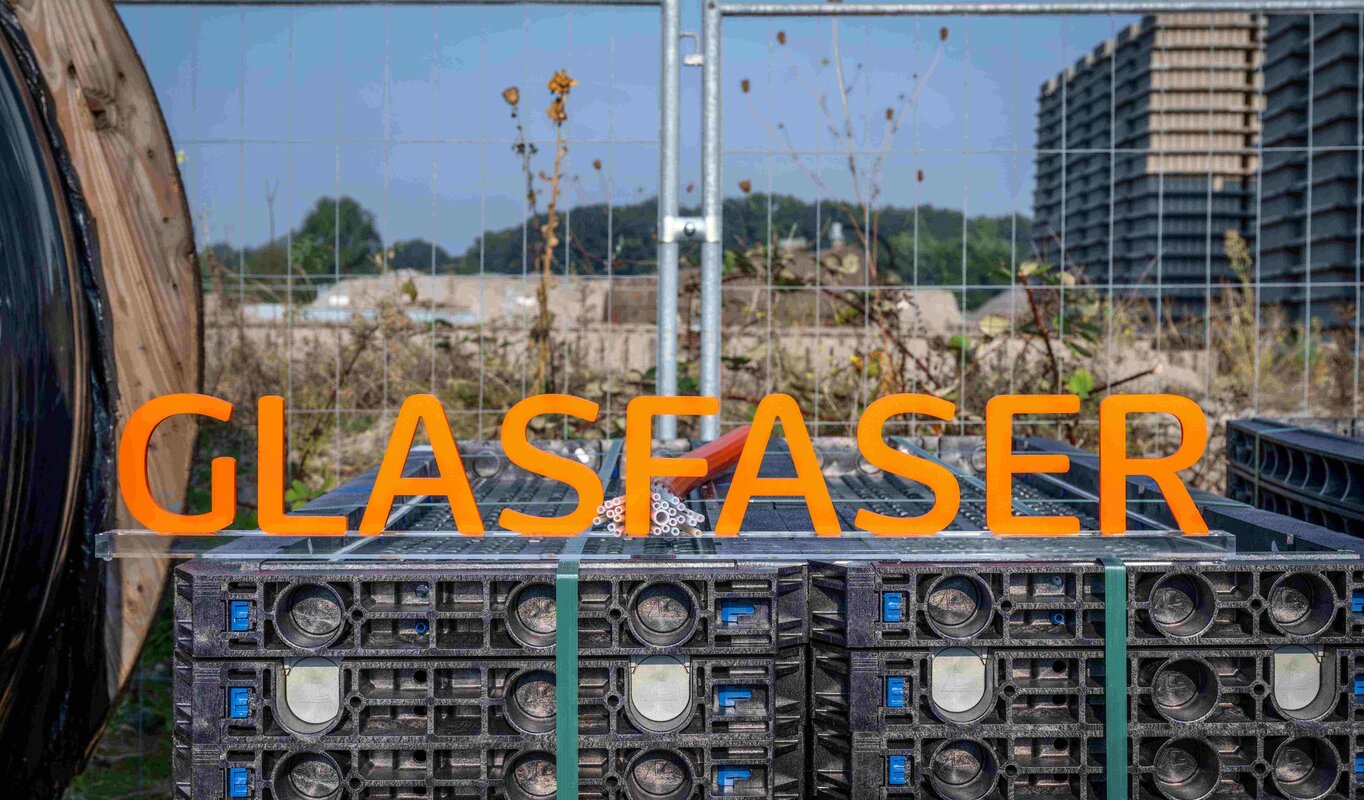 Schriftzug "Glasfaser" auf einem Baustellenlager