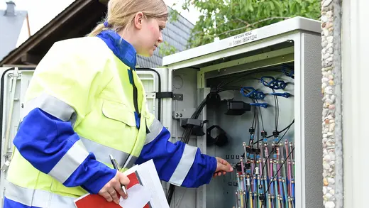 Eine Mitarbeiterin prüft den Verteilerschrank.