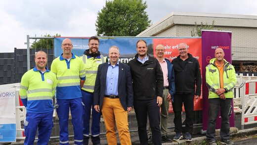 Auf dem Foto sind acht Personen zu sehen, darunter Thomas Schwefer (Westnetz), Heiko Grebe (Westconnect), Adiran Biggeleben (Westnetz), Wolf Blesken (Bürgermeister Gemeinde Möhnesee), Johannes Kobeloer (Westenergie), Klaus Peter Teipel (Ortsvorsteher Körbecke), Jürgen Schmitt (Leiter Fachbereich Gemeindeentwicklung Möhnesee) und Maksym Zakharov (Tiefbauunternehmen MDNetworks).