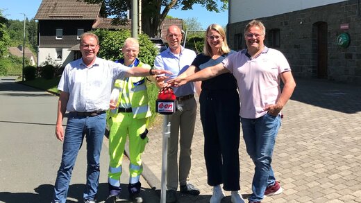 Auf dem Foto sind fünf Personen zusehen, darunter Achim Loos (Kommunales Partnermanagement Westenergie), Dominik Will (Bauleiter Westnetz), Heiko Grebe (Leiter Regionalmanagement Westconnect), Nicole Reschke (Bürgermeisterin Freudenberg) und Markus Blusch (Ortsvorsteher Mausbach).