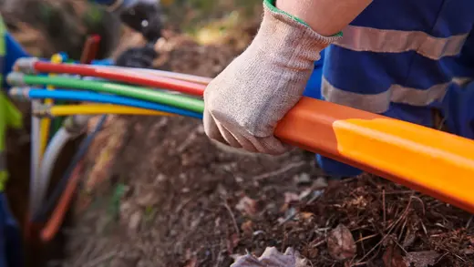 Die Hand eines Mitarbeiters hält Glasfaser.